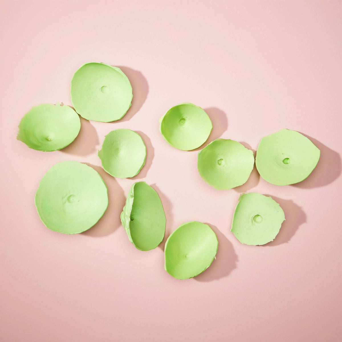 Array of cured silicone areola molds in green, demonstrating the pre-surgery mold-making process — RmonyCare Pre-Surgery Kit